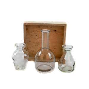 Glasvasen-Set auf einem Holzbrett. Dekorations-Set als Tischdekoration mit 3 Glasflaschen